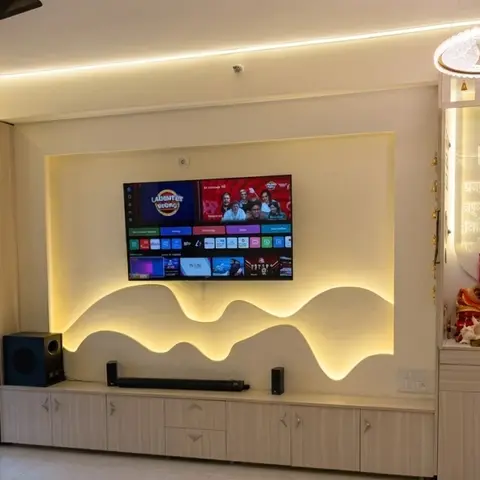 Living room TV wall with a sculpted wave-pattern backlit panel behind the television, a floating storage console with soundbar and subwoofer
