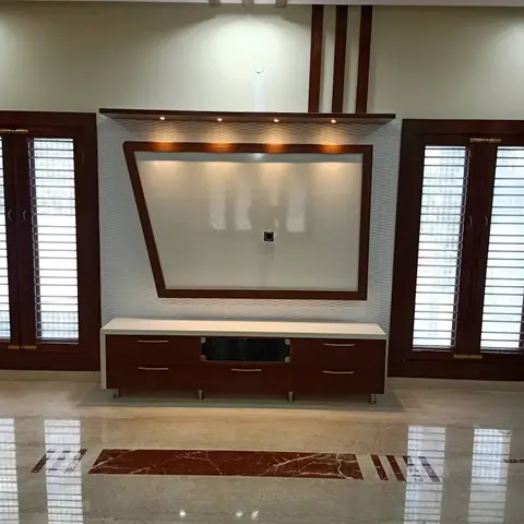 Living room TV wall with an angled wood-framed panel over a textured 3D wall finish and a dark wood console on an inlaid marble floor strip