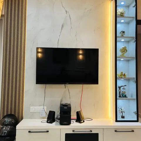 Living-room TV wall with book-matched marble cladding, a backlit LED strip beside a fluted wood panel, a white TV console