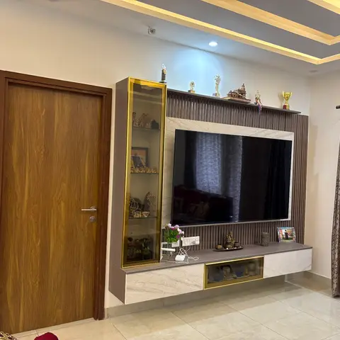 Living room TV wall with dark vertical fluted wood panelling, a marble-look stone backdrop behind the mounted TV