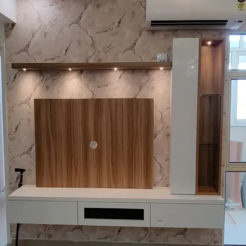 Living-room TV wall with marble-pattern wallpaper, a floating wood-veneer TV panel, a white console with side display tower, and a cove-lit stepped ceiling.