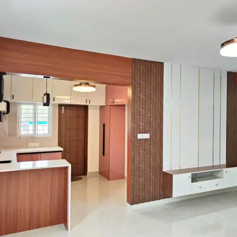 Living room TV wall with vertical gold-striped wood panelling and a floating white TV console, kitchen visible through the archway on the left