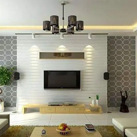 Living room TV wall with white slatted panelling flanked by grey circle-pattern wallpaper under a cove-lit ceiling and a black-shade chandelier