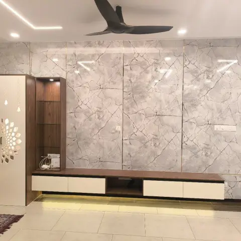 Living room wall clad in four bays of grey veined marble sheet split by thin gold strips