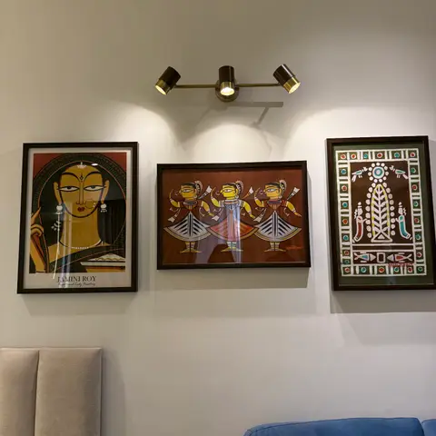 Living room wall styled with a curated trio of traditional Indian folk-art prints (Jamini Roy
