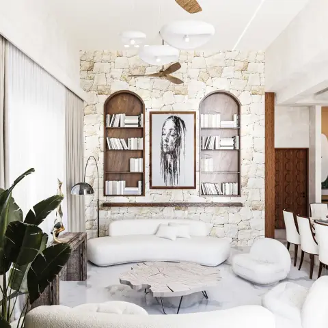 Living room where a rough split-face stone wall carries two arched walnut bookshelf niches flanking a dripping-ink portrait, with a curved white boucle sofa