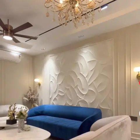 Living room where a sculpted white plaster relief panel framed in cream mouldings sits behind a royal-blue velvet sofa