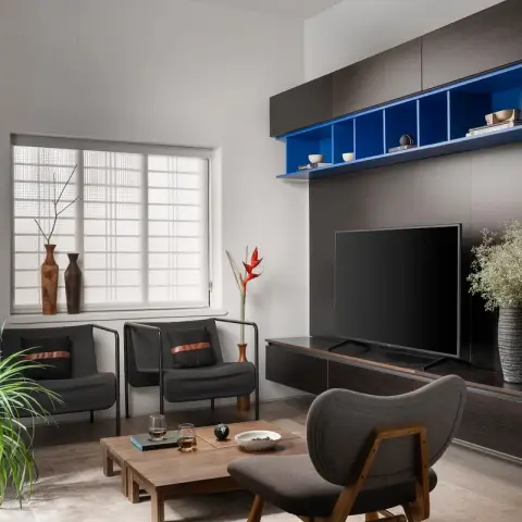 Living room where a wenge-veneer media wall carries a cobalt-blue lacquered open shelf run above the TV