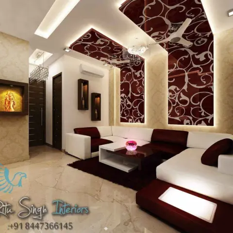 Living room where maroon panels with white scrollwork overlay climb the wall and fold across the angular false ceiling, backlit at every edge