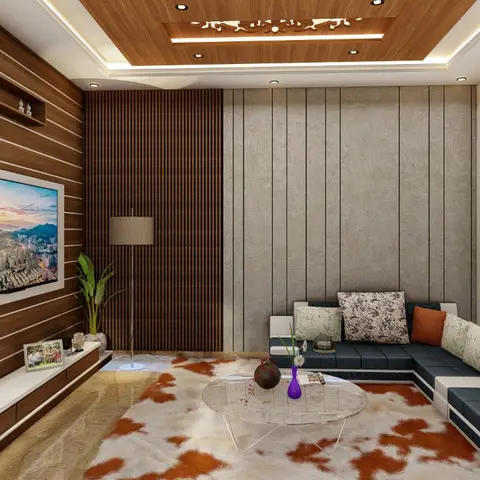 Living room with a backlit wood jaali panel beside a fluted-wood TV wall and a charcoal corner sofa on an orange-and-white cowhide-pattern rug.