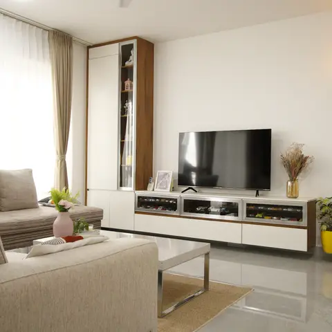 Living room with a beige sofa facing a floating walnut-and-white TV unit with glass display drawers for model cars