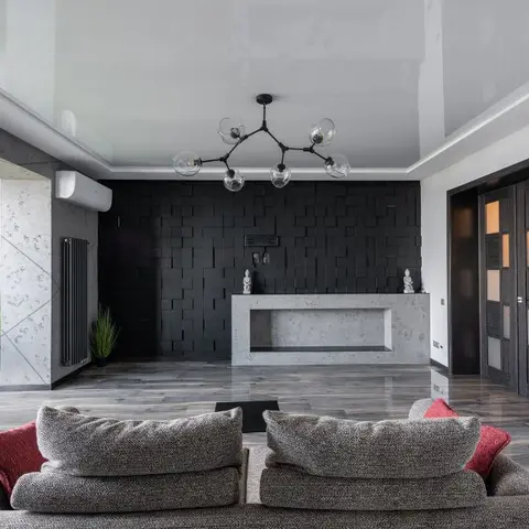Living room with a black 3D cube-textured feature wall, a glossy stretch ceiling, and a molecular-style chandelier over a concrete-look console.