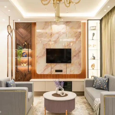 Living room with a book-matched marble and fluted-copper TV feature wall, glass display shelving styled with decor