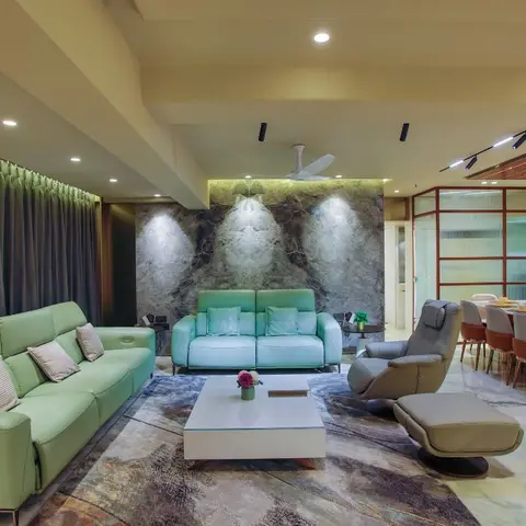 Living room with a book-matched grey-veined marble feature wall lit by spotlights