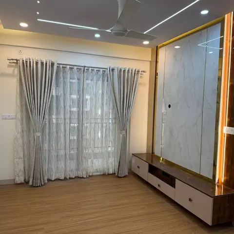 Living room with a book-matched marble TV feature wall framed in gold trim and backlit fluted wood panelling