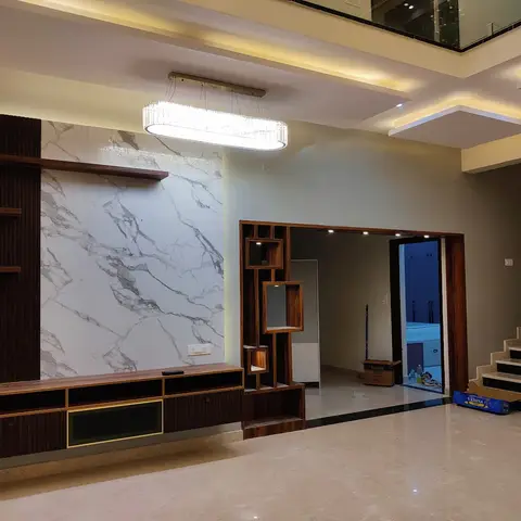 Living room with a bookmatched marble-clad TV wall flanked by dark fluted wood panelling and a gold-trimmed floating console