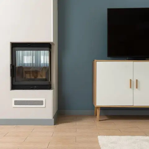 Living room with a built-in fireplace insert, a petrol-blue accent wall, and a mid-century TV console on tapered wood legs.