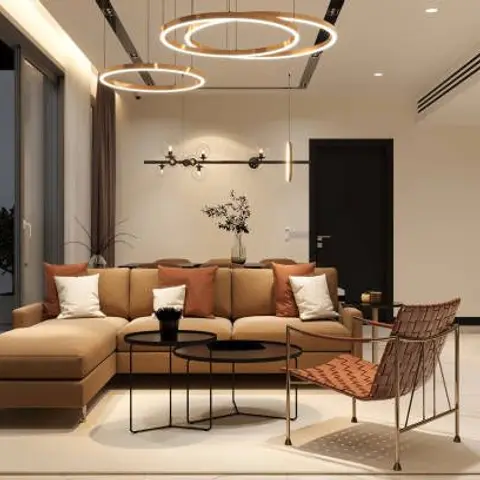 Living room with a camel L-shaped sectional, layered black round coffee tables and a cluster of oversized ring pendant lights overhead