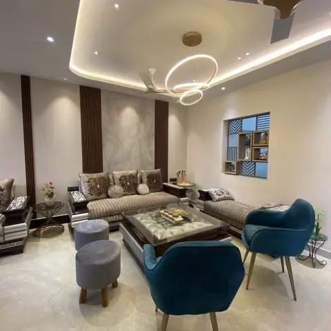 Living room with a carved wood sofa upholstered in embroidered fabric, a marble slab feature wall flanked by fluted wood pilasters