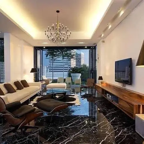 Living room with a cluster chandelier over black glossy marble flooring, a white sectional sofa, a black leather lounge chair and ottoman