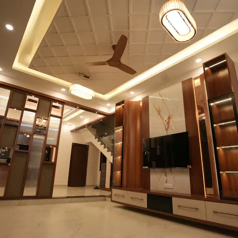 Living room with a coffered cove-lit false ceiling, a walnut TV unit set against a veined marble backdrop