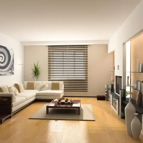 Living room with a cream L-shaped sectional sofa and dark wood coffee table on an area rug, a spiral abstract art piece on the side wall