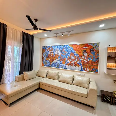 Living room with a cream leather L-shaped sofa facing a large traditional mural painting of a mythological scene, lit by ceiling track spotlights.