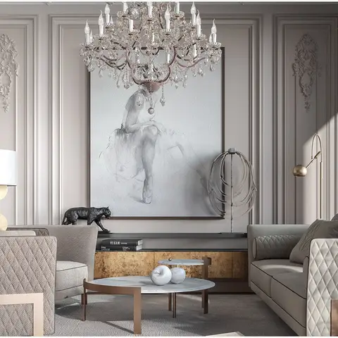 Living room with a crystal chandelier hung over a black-and-white ballerina artwork, diamond-quilted taupe sofas, and a gold-leaf console table.
