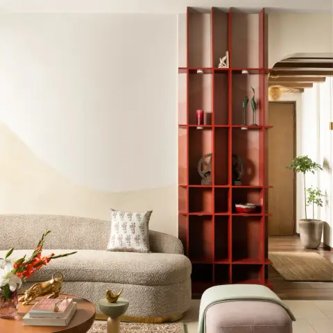 Living room with a curved bouclé sofa on a brass plinth against a two-tone hand-blended wall