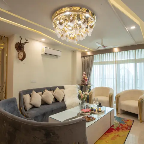 Living room with a curved charcoal velvet sofa and cream tub chairs around a mirrored coffee table