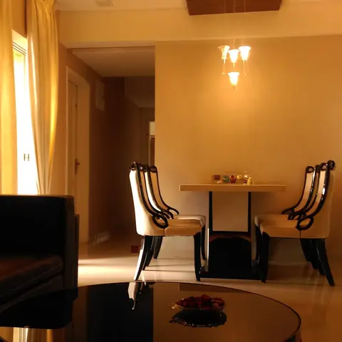 Living room with a dark leather sofa and round glass coffee table in the foreground