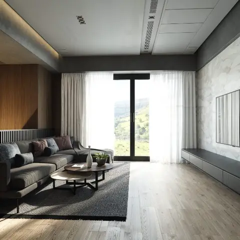 Living room with a dark sectional sofa facing a marble slab TV wall, floor-to-ceiling sheer-curtained windows framing a mountain view