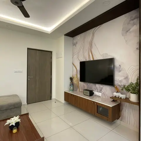 Living room with a floating walnut TV console against a marbled grey wallpaper feature wall with gold vein detailing