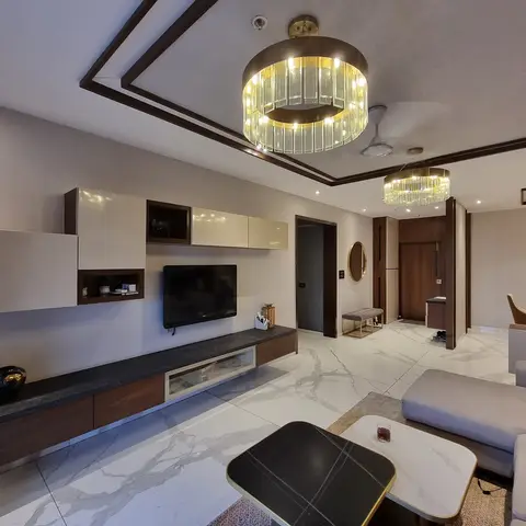 Living room with a floating walnut-and-cream TV console, dual tiered drum chandeliers, bookmatched marble flooring