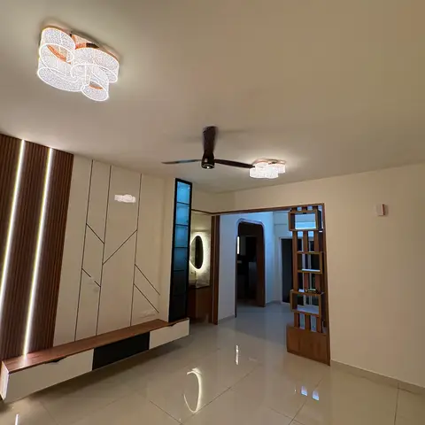 Living room with a fluted-wood and geometric-line inlay TV feature wall, a floating wood-and-white TV console, and twin crystal-style flush ceiling lights