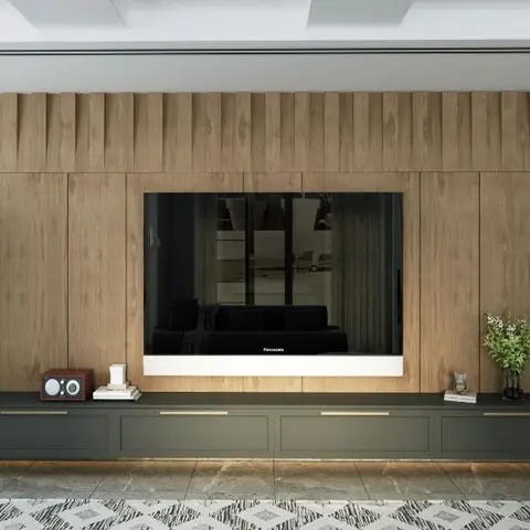 Living room with a fluted wood-panelled TV wall, a dark green low console with brass handles, and matching potted palms in copper planters on either side.