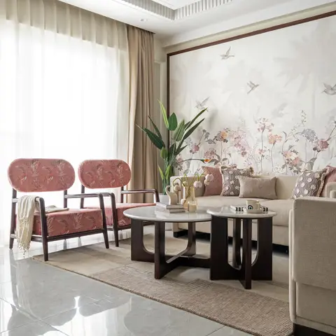 Living room with a framed floral bird-print wallpaper mural, a sputnik-style gold chandelier, a cream sofa flanked by pink patterned armchairs