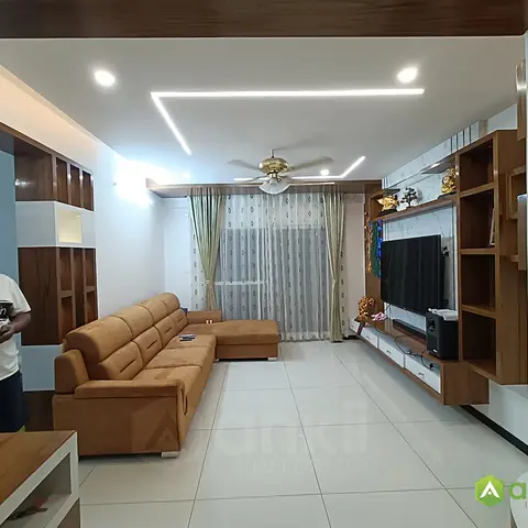 Living room with a full-wall wood TV unit featuring a mirrored backsplash and open display cubbies