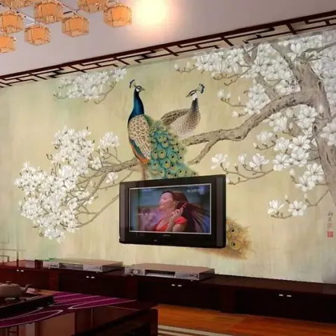 Living room with a full-wall peacock and magnolia mural wallpaper, a low wood TV console, and a cluster of amber lantern pendant lights.