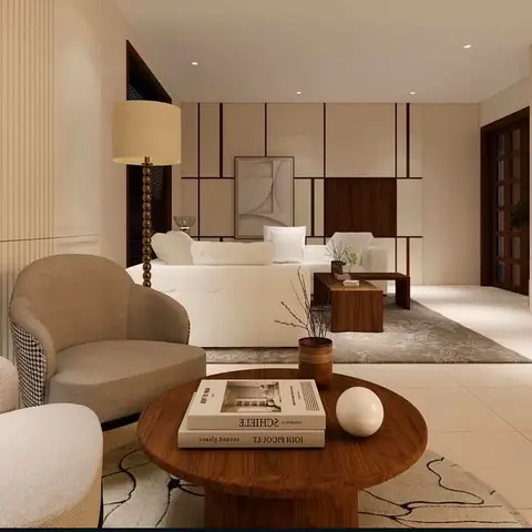 Living room with a geometric wood-and-cream panelled feature wall behind a white sofa, houndstooth-trim armchairs and a round wood coffee table