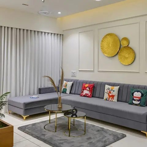 Living room with a grey channel-tufted sectional dressed in colourful animal-print cushions, gold sunburst wall discs
