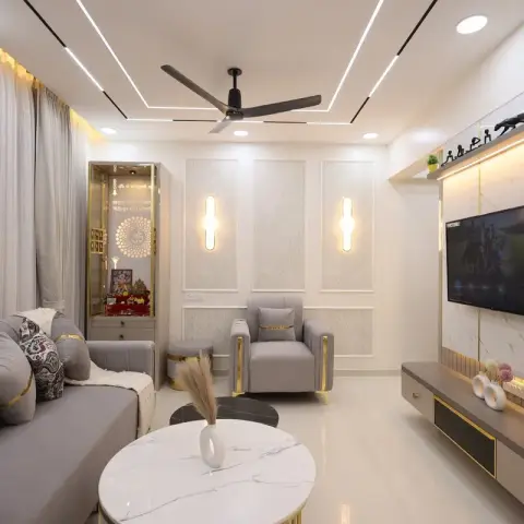 Living room with a grey sofa set trimmed in gold, a marble-clad TV wall with brass inlay lines, damask wall panelling with tube sconces