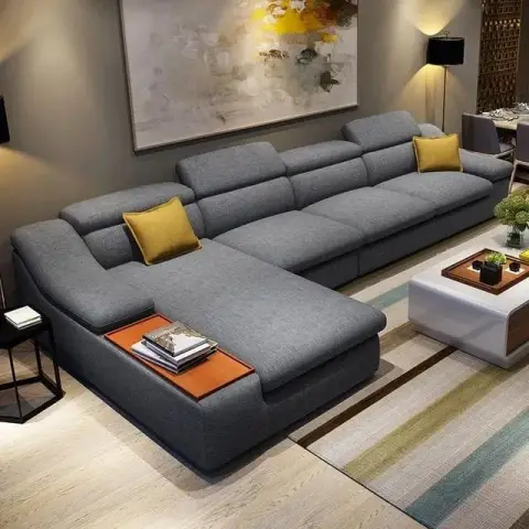 Living room with a large grey L-shaped sofa with adjustable headrests, mustard accent cushions, a big abstract canvas and a striped area rug.