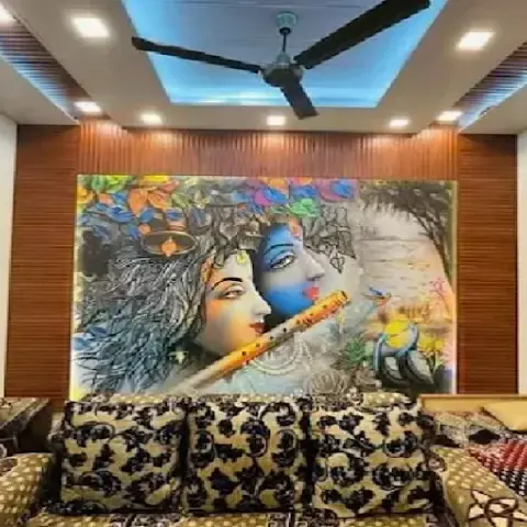 Living room with a large hand-painted Radha-Krishna mural framed by fluted wood wall panelling, under a cove-lit false ceiling, with floor seating in front.
