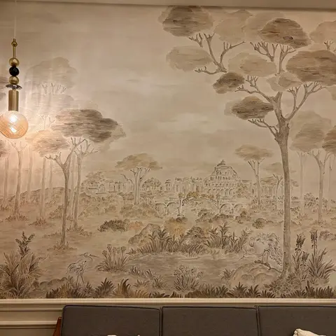 Living room with a large-scale sepia-toned scenic mural wallpaper depicting a classical landscape, an amber glass globe pendant light