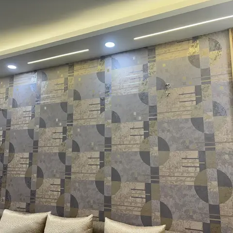 Living room with a large-scale geometric wallpaper feature wall bordered by wood fluted panelling and a cove-lit ceiling trim.