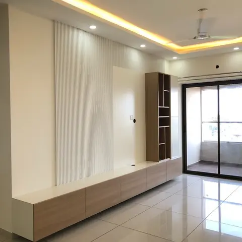 Living room with a long floating wood-tone TV console beside an open display shelf tower