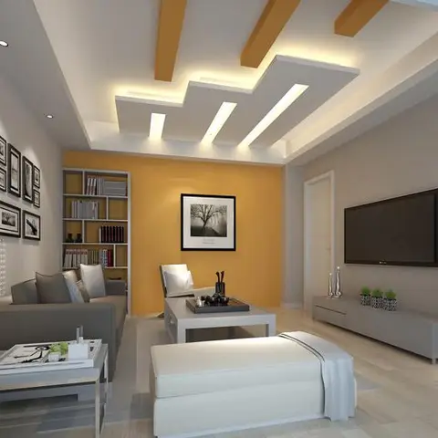 Living room with a mustard accent wall, a gallery of framed prints, and a stepped POP false ceiling with linear cove lighting.