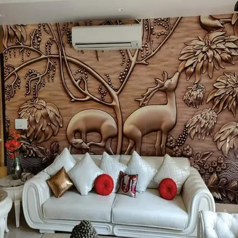 Living room with a quilted white leather sofa styled with red and gold accent cushions against a large 3D-textured deer-and-foliage relief wallpaper mural.