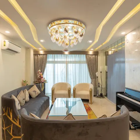 Living room with a radial sunburst cove-lit POP ceiling and crystal chandelier, charcoal velvet sofas embroidered with a gold branch motif